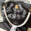 Chanel — Bolso negro acolchado con detalles dorados