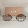 Miu Miu — Gafas ovaladas con lentes gris cálido