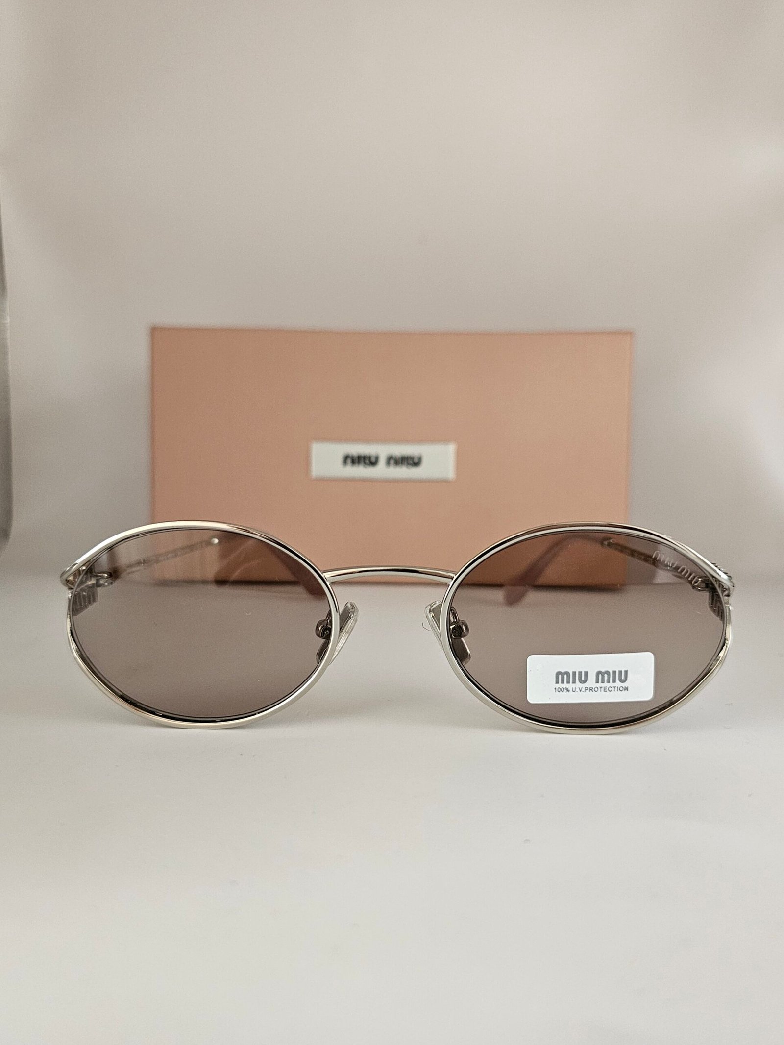 Miu Miu — Gafas ovaladas con lentes gris cálido