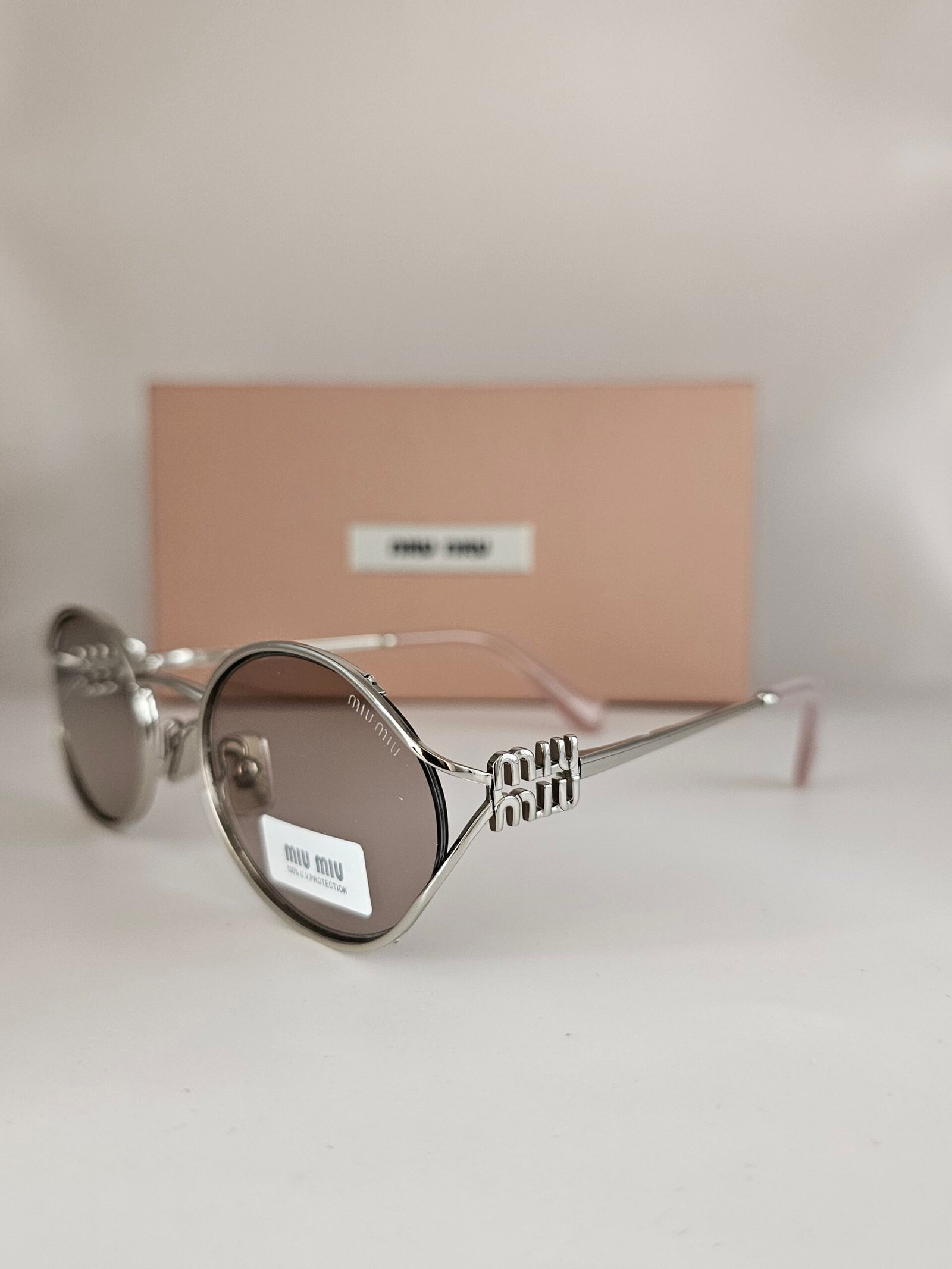 Miu Miu — Gafas ovaladas con lentes gris cálido