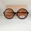 Miu Miu — Gafas redondas negras con lentes ámbar