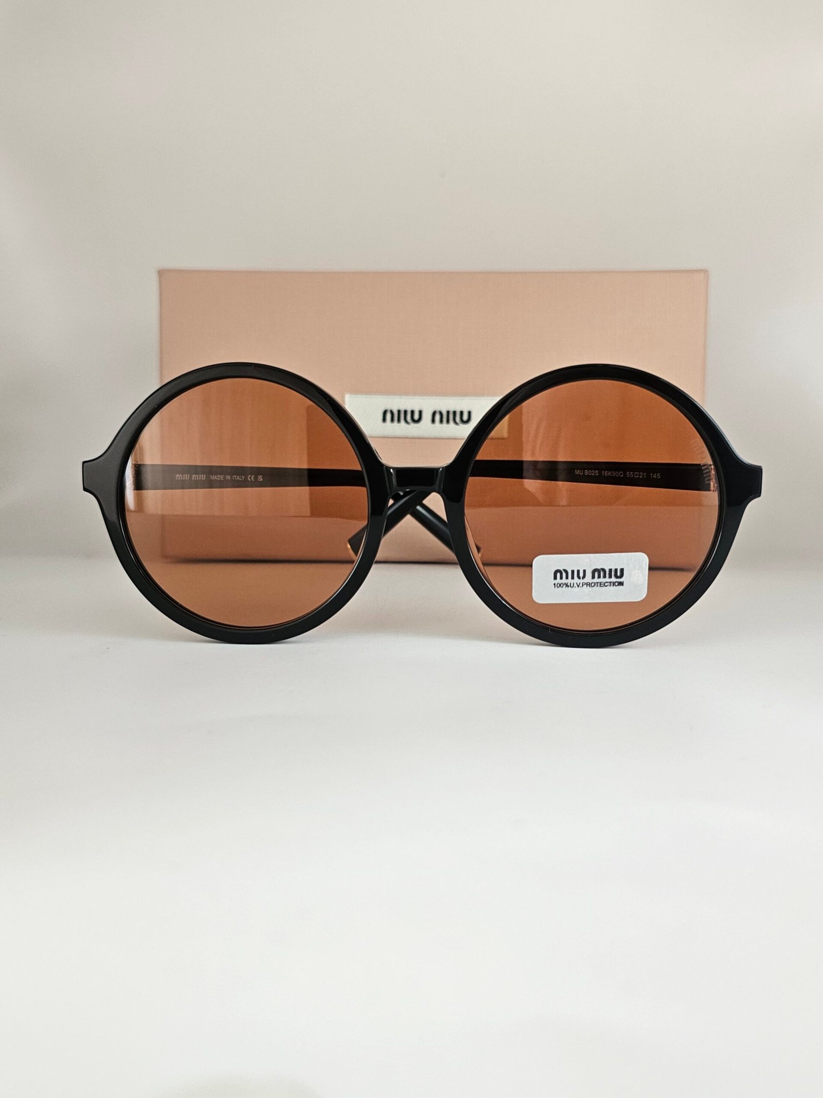 Miu Miu — Gafas redondas negras con lentes ámbar
