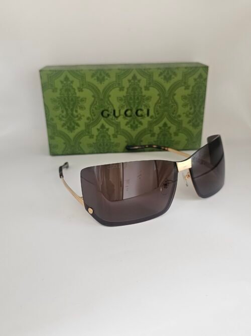 Gucci — Gafas envolventes doradas con lentes marrones