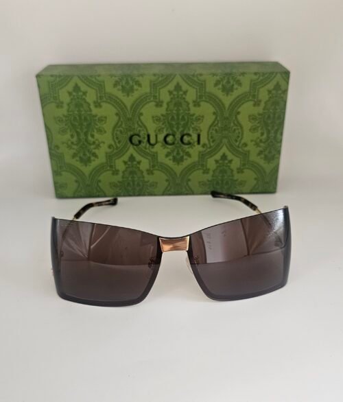 Gucci — Gafas envolventes doradas con lentes marrones