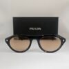 Prada — Gafas negras con lentes beige