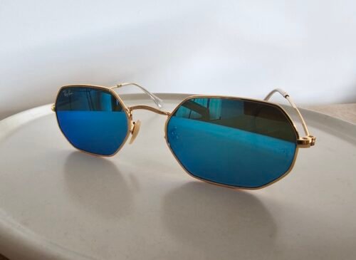 Ray-Ban — Gafas geométricas doradas con lentes azules