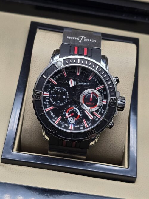 Ulysse Nardin — esfera negra con detalles rojos y correa a rayas