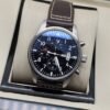 IWC — esfera negra y correa marrón con costuras claras