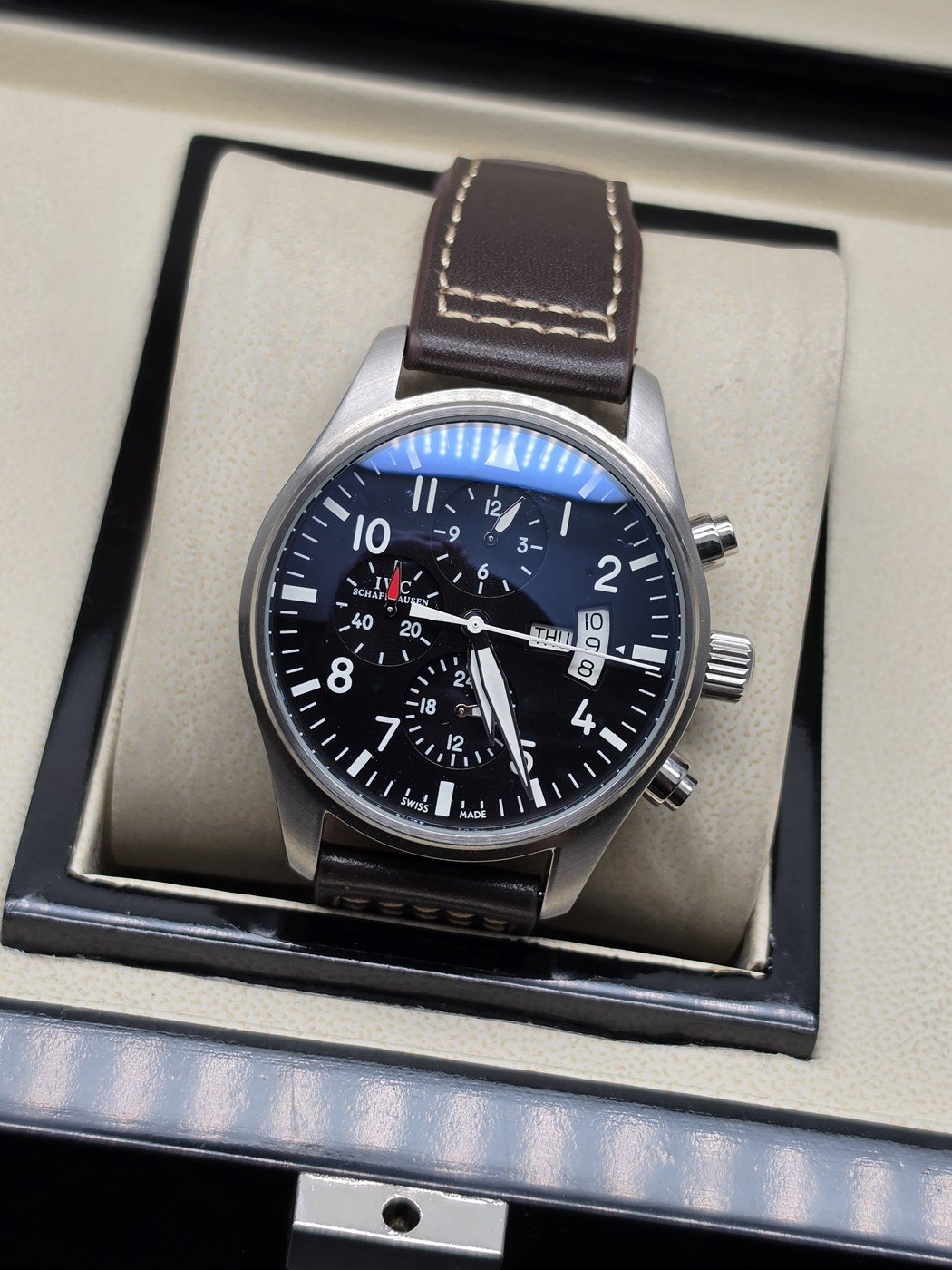 IWC — esfera negra y correa marrón con costuras claras