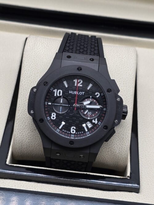 Hublot — esfera negra con apertura y caja gris oscura
