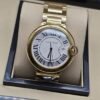 Cartier — esfera blanca redonda y brazalete dorado