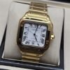 Cartier — esfera blanca cuadrada y brazalete dorado