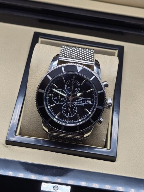 Breitling — esfera negra y brazalete de malla plateado
