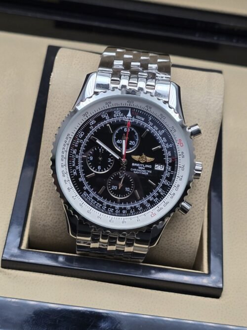 Breitling — esfera negra con detalles rojos y brazalete plateado