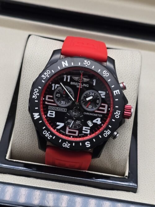 Breitling — esfera negra con detalles rojos y correa roja