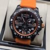 Breitling — esfera negra deportiva y correa naranja
