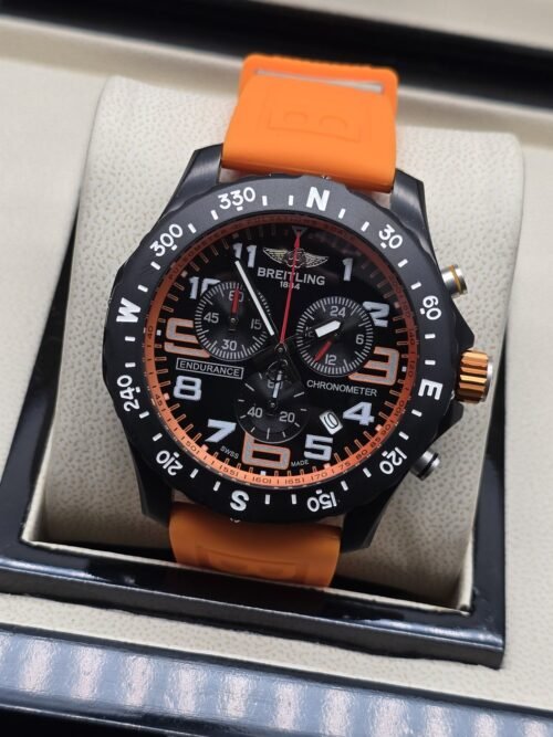 Breitling — esfera negra deportiva y correa naranja