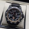 Breitling — esfera negra con detalles dorados y correa negra