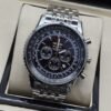 Breitling — esfera negra con subesferas oscuras y brazalete plateado