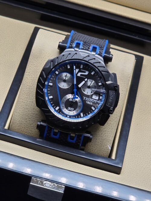 Tissot — esfera negra con detalles azules y correa a rayas