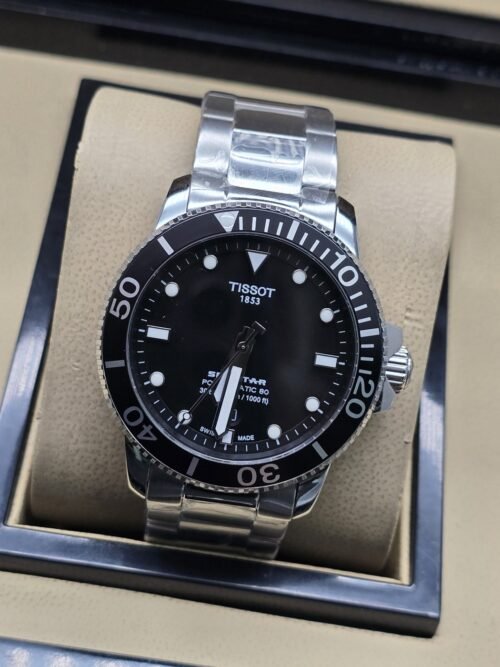 Tissot — esfera negra sencilla y brazalete plateado