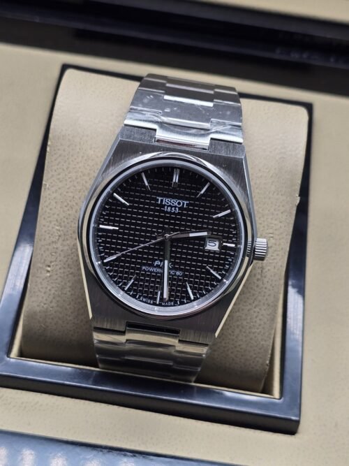 Tissot — esfera negra texturizada y brazalete plateado