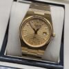 Tissot — esfera dorada texturizada y brazalete dorado