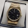 Tissot — esfera negra y brazalete dorado