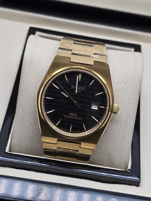 Tissot — esfera negra y brazalete dorado