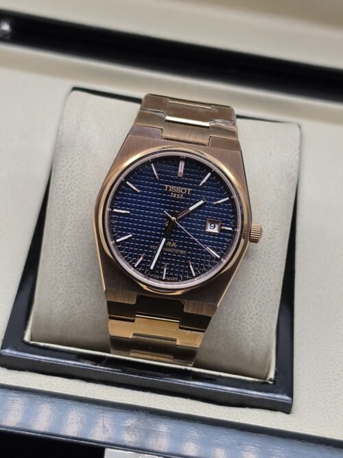 Tissot — esfera azul texturizada y brazalete dorado