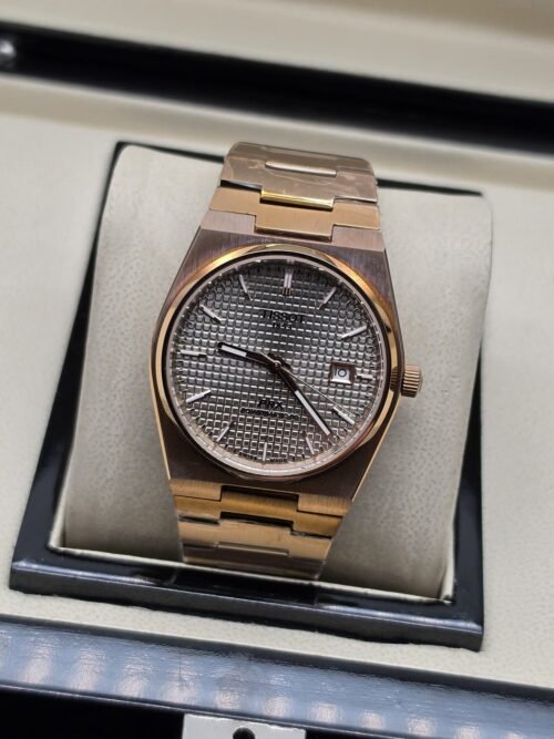 Tissot — esfera gris texturizada y brazalete rosado
