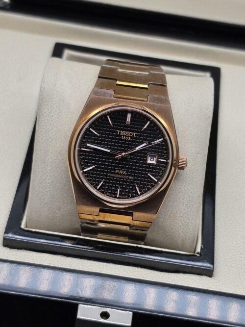 Tissot — esfera negra texturizada y brazalete rosado