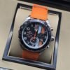 TAG Heuer — esfera negra con detalles naranjas y correa naranja