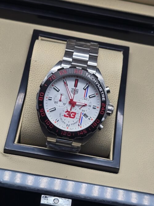 TAG Heuer — esfera blanca con detalles rojos y brazalete plateado