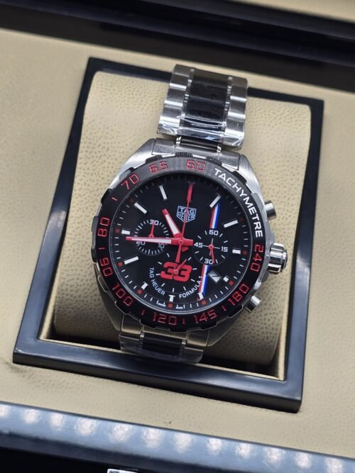TAG Heuer — esfera negra con detalles rojos y brazalete plateado