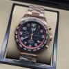TAG Heuer — esfera negra con detalles rojos y brazalete rosado