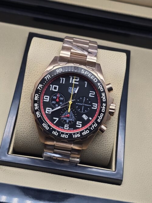 TAG Heuer — esfera negra con detalles rojos y brazalete rosado