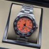 TAG Heuer — esfera naranja y brazalete plateado