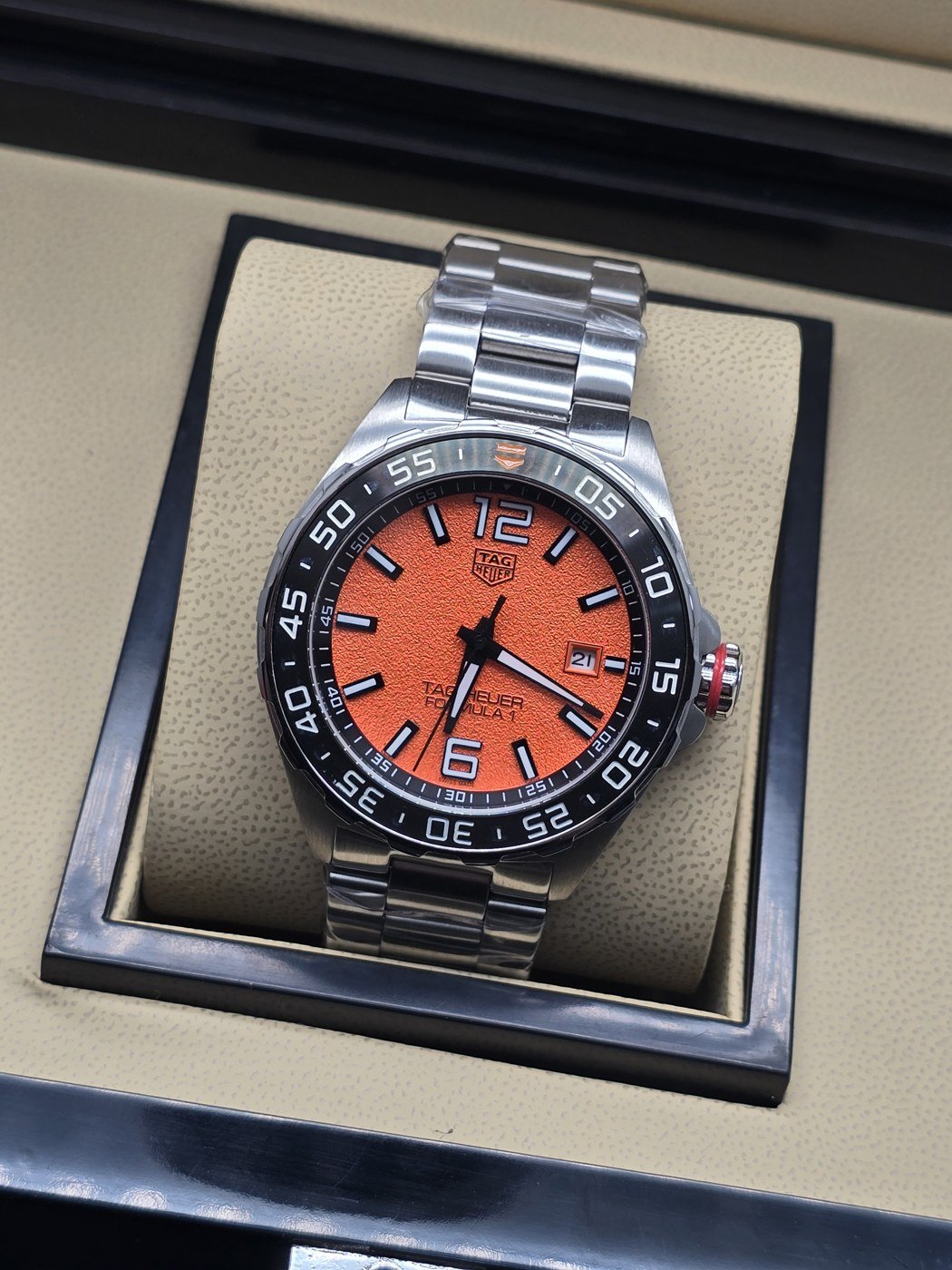 TAG Heuer — esfera naranja y brazalete plateado