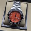 TAG Heuer — esfera naranja texturizada y brazalete plateado