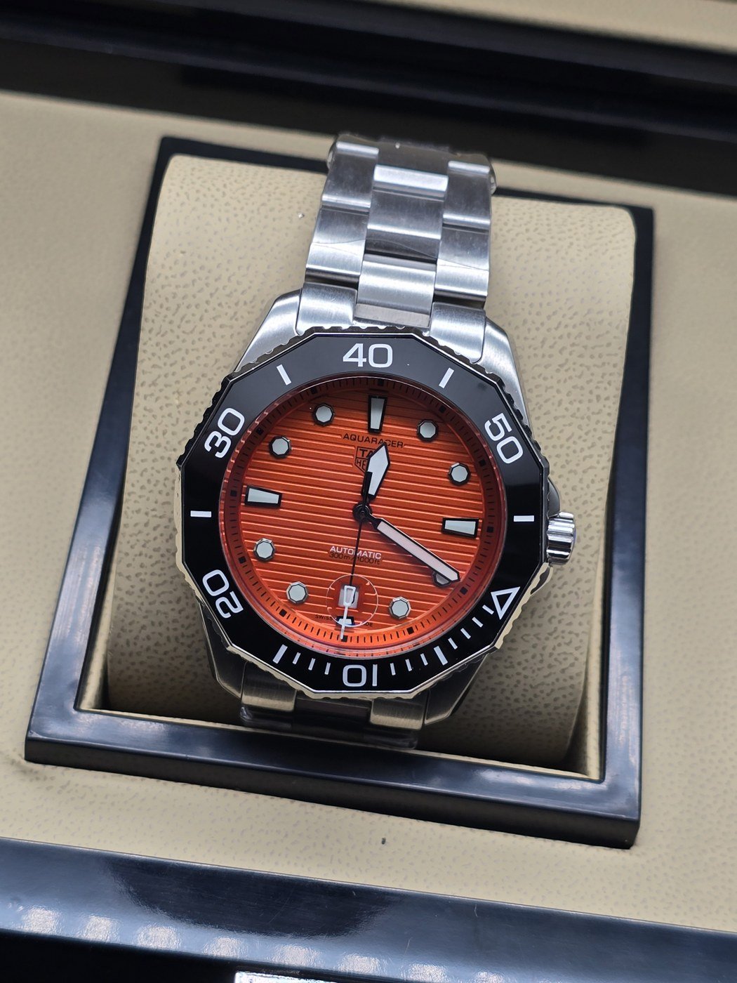 TAG Heuer — esfera naranja texturizada y brazalete plateado