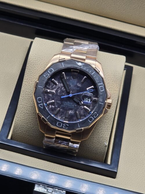 TAG Heuer — esfera oscura con detalles azules y brazalete rosado