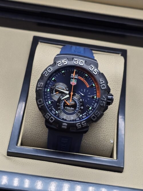 TAG Heuer — esfera oscura con detalles naranjas y correa azul