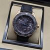 TAG Heuer — esfera oscura con detalles azules y correa negra