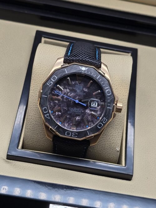 TAG Heuer — esfera oscura con detalles azules y correa negra