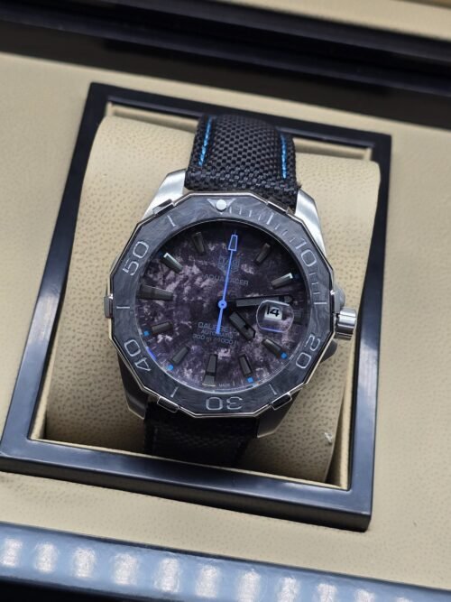 TAG Heuer — esfera oscura con detalles azules y correa de costuras azules