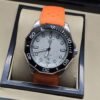 TAG Heuer — esfera blanca y correa naranja