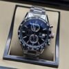 TAG Heuer — esfera negra con dos subesferas y brazalete plateado