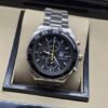 TAG Heuer — esfera negra con detalles amarillos y brazalete plateado
