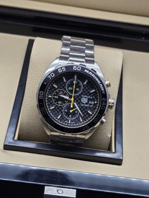 TAG Heuer — esfera negra con detalles amarillos y brazalete plateado